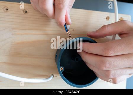 Connecting a cable inside a black ceiling light canopy for DIY assembly Stock Photo
