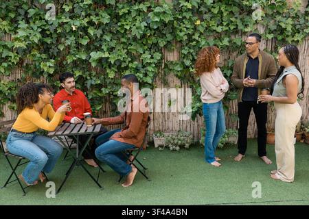 Diverse friends enjoying coffee and conversation outdoors Stock Photo