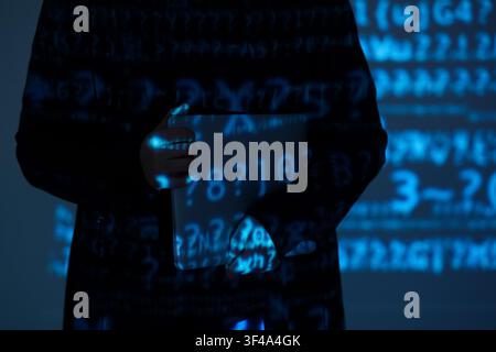 Hacker with laptop and projection of programming code in dark room, closeup Stock Photo