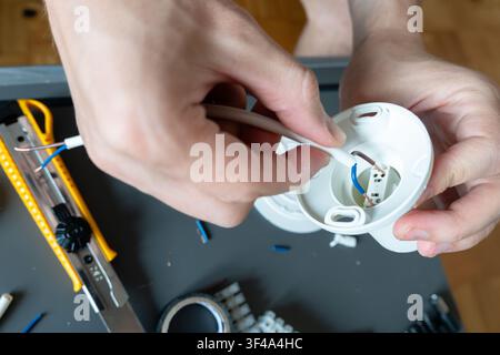 Connecting electrical wires inside a ceiling light mounting base Stock Photo
