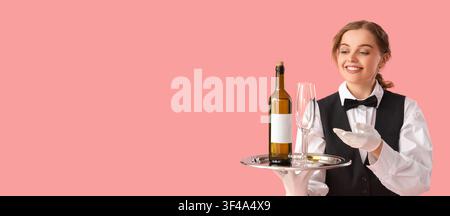 Smiling young female waiter in uniform holding a silver tray with a bottle of wine and an empty glass, the professional staff member is isolated on a Stock Photo