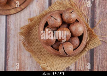 Bowl of Macadamia nuts on a wooden table Stock Photo