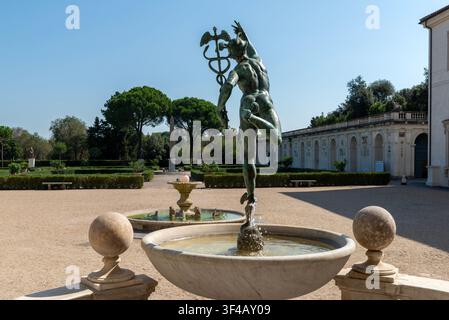 Bronze Mercury fountain sculpture and circular marble basin overlooking the formal parterre garden of Villa Medici at the French Academy in Rome. Stock Photo