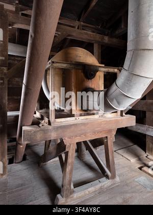 Millstadt Mill, Millstadt, Illinois, USA. A round wood-cased machine on a timber trestle, fed by galvanized ducting. Stock Photo