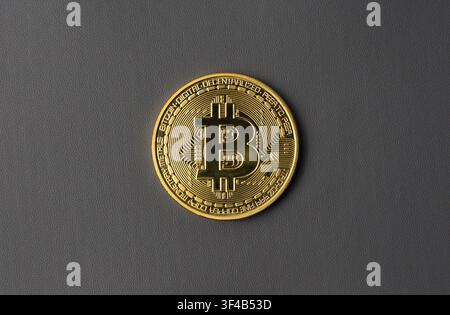 Gold Bitcoin coin placed on dark gray background, suitable for cryptocurrency, blockchain finance Stock Photo