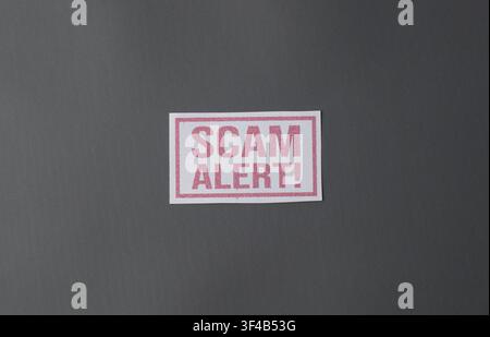 Scam alert warning sign on gray background with copy space, ideal for fraud prevention, online security, financial scam, phishing danger Stock Photo