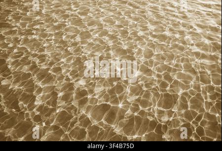 Dancing shadows and lights of glittering water surface in the pool Stock Photo