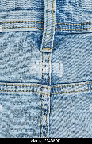 Texture light blue washed denim jeans showing stitching details and vertical belt loop Stock Photo