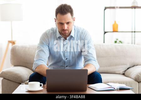 Guy listening to music online and using laptop Stock Photo