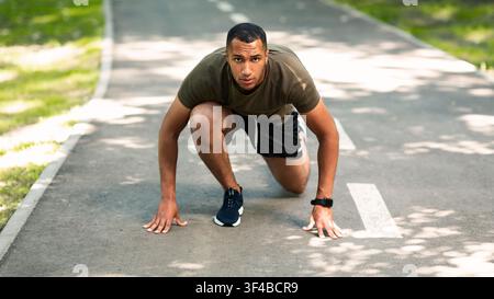 Serious black sportsman ready to run marathon race at park Stock Photo