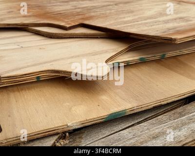 Close-up of stacked plywood sheets with curved cutouts and exposed layered edges. Ideal for construction, woodworking, furniture manufacturing, carpen Stock Photo