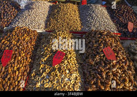 Various dried dates, figs, pistachios, nuts and almonds are on display for sale at a sales stand, souk, bazaar, Marrakech, Maghreb, Morocco, North Afr Stock Photo