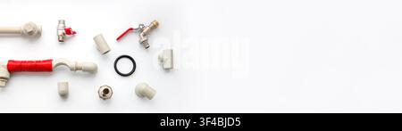 A flat lay composition of various plumbing supplies, including plastic pipes, fittings, valves, and connectors on a white background with empty copy Stock Photo