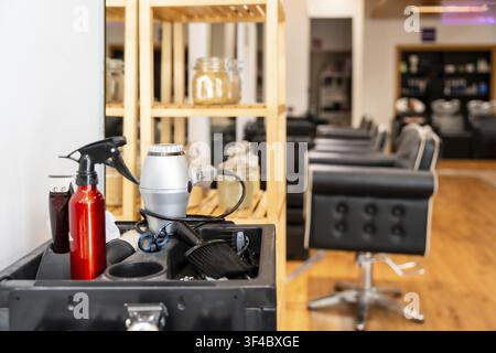 Styling tools and equipment arranged on a barber cart. Including a hair dryer and spray bottle. Defining the professional workspace of a hair salon or Stock Photo