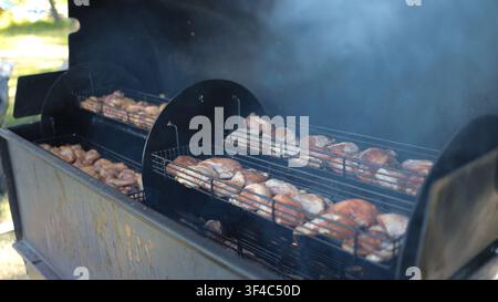 Detailed view of delicious barbecue meat sizzling on steel grill grate with rising smoke Stock Photo