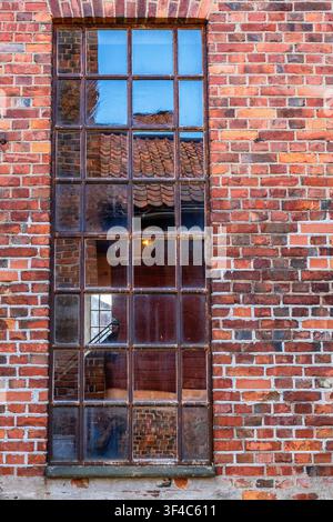 Old beautiful window on an industrial building of bricks Stock Photo