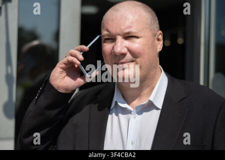 Confident mature businessman talking on smartphone outside office building. Business negotiation, communication, leadership and successful corporate l Stock Photo