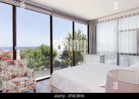 Bright and spacious modern bedroom interior featuring a comfortable double bed Stock Photo