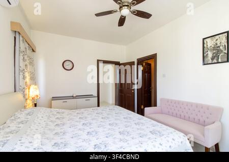 Bright and spacious modern bedroom interior featuring a comfortable double bed Stock Photo