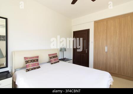 Bright and spacious modern bedroom interior featuring a comfortable double bed Stock Photo