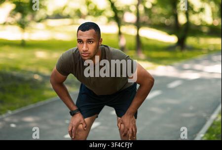 Young African American runner taking break after his training at park Stock Photo