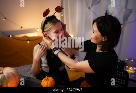 Mother And Daughter Preparing And Dressed For Halloween Celebration Stock Photo
