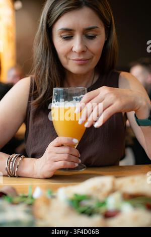 Woman Enjoying White Wheat Beer In A Bar With Snacks Stock Photo