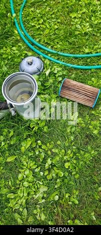 Cleaning cartridge filter for above ground swimming pool during maintenance in backyard garden Stock Photo