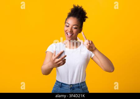 Happy black lady taking selfie using mobile phone Stock Photo