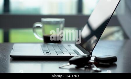 A Contemporary Workspace Featuring a Laptop, Coffee, and Keys, Capturing the Essence of Modern Productivity and Minimalism. Stock Photo