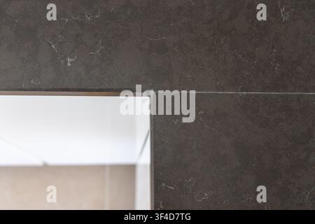 A close-up view of a dark gray engineered stone surface, showcasing its fine texture and delicate white mineral inclusions Stock Photo