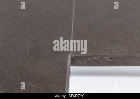 A detailed view of a modern dark grey quartz surface showcasing its fine texture and delicate white veining patterns Stock Photo