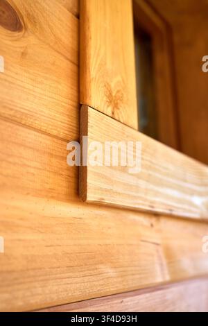 Close up view showing detailed joinery of natural pine wood window casing and horizontal exterior timber shiplap cladding on modern rustic house facad Stock Photo