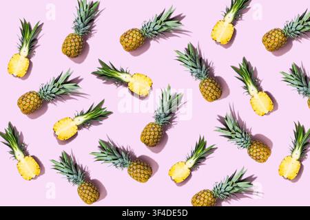 Whole and sliced pineapples scattered on pastel pink background Stock Photo
