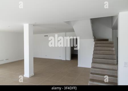 An empty, newly constructed residential space featuring neutral tones and a minimalist design, ready for furnishing Stock Photo