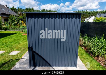 Anthracite garden shed providing functional storage solution along property line Stock Photo
