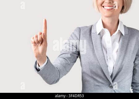 Closeup view of businesswoman touching imaginary screen on light background, space for your design Stock Photo