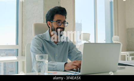 Happy Arabian Indian business man celebrating online success laptop indoor office amazed shocked male businessman victory manager guy worker win Stock Photo