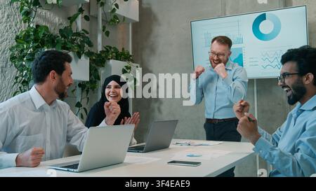 Happy multiethnic diverse business partners celebrating victory office ethnic Arabian Indian businessmen muslim businesswoman achieving successful Stock Photo