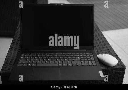 A modern black computer mouse sits on a white surface Stock Photo - Alamy