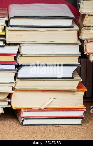 A pile of old books on a shelf in a library. Selective focus. Paperwork. Stack of old books. Education background. Back to school concept. Stock Photo
