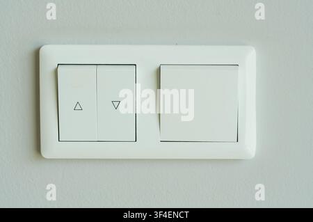 Close-up of white electric light switch on white wall background. Stock Photo