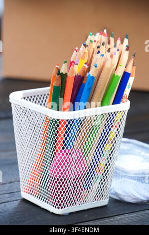 Colorful pencils in a basket on the wooden table, stock photo Stock Photo
