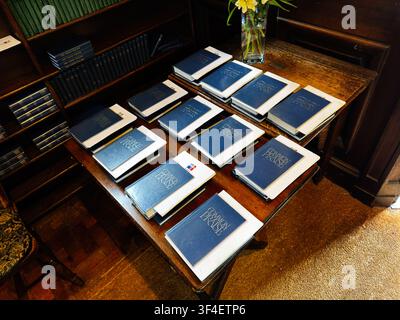 Manchester, UK - May 10, 2026: Blue Common Praise hymn books neatly arranged on a wooden table in a historic Manchester, UK church. Stock Photo
