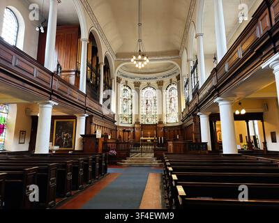 Manchester, UK - May 10, 2026: Bright historic St Ann's church interior in Manchester, UK with stained glass, wooden pews and ornate altar details. Stock Photo