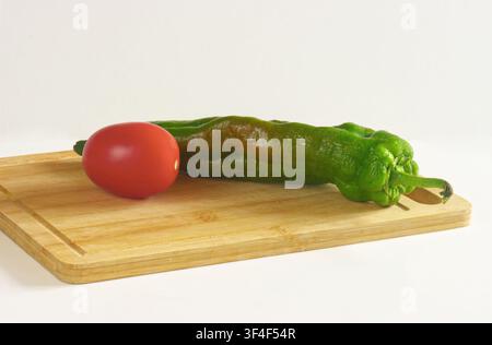 fresh red bell pepper and cherry tomatoes isolated on white background with green leaf and green leaves Stock Photo