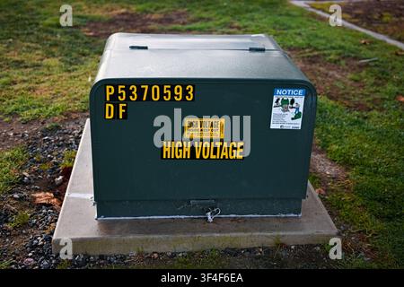 Electrical utility box marked High Voltage installed on a concrete pad in Serfas Club Park, indicating underground electrical infrastructure within a Stock Photo