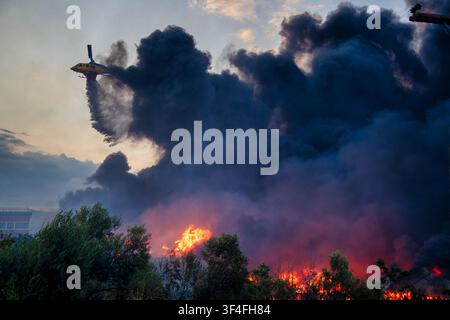A firefighting helicopter drops water over the Oraiokastro wildfire in Thessaloniki on July 5,2026, highlighting the severity of drought and climate c Stock Photo