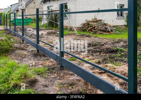 Modern Steel Fence Frame Installation Around Residential Property During Home Improvement Construction Stock Photo