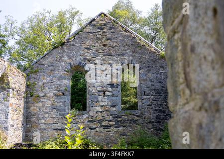 Abandoned Roofless Church Ruins Overgrown with Vegetation Stock Photo